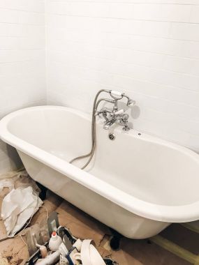 banyo yenileme kavramı. şık beyaz küvet, retro musluk ve modern beyaz seramik duvar. 