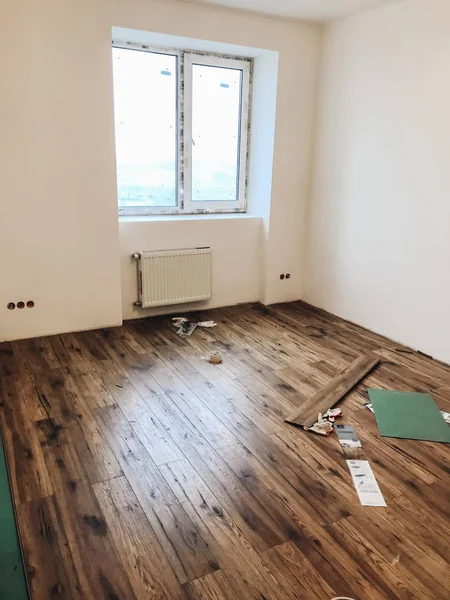 部屋の床改修のコンセプト スタイリッシュな木製ラミネート インストール モダンな白い壁 — ストック写真