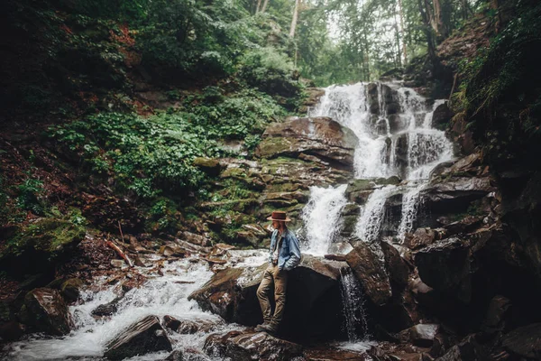 Fernweh Und Reisekonzept Stilvoller Reisender Mit Hut Posiert Wasserfall Hält — Stockfoto