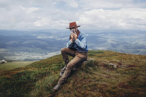 Koncepcja Wanderlust Podróży Podróżnik Mężczyzna Kapeluszu Aparatu Fotograficznego Szczycie Góry — Zdjęcie stockowe