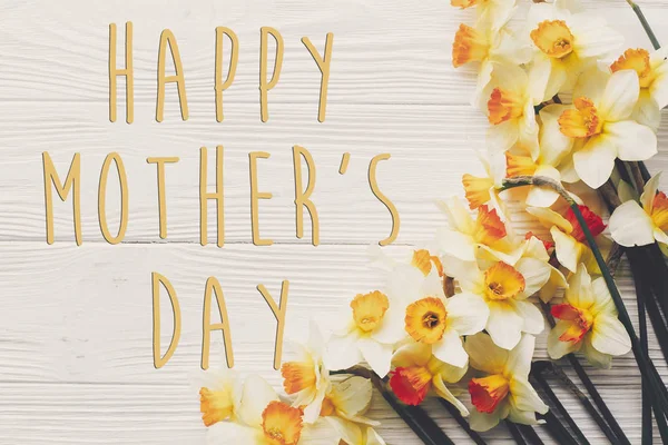 mutlu anneler günü metin. rustik ahşap arka plan üstten görünüm üzerinde çiçekler nergis bahar düz yatırın. Şık modern mutlu anneler günü tebrik kartı. metin için yer
