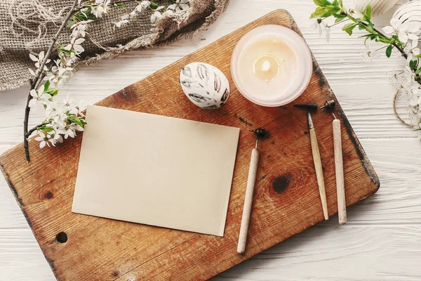 Modern Paskalya yortusu yumurta taze bahar çiçekleri rustik zemin üzerine üstten görünüm. Mutlu Paskalya tebrik kartı ile metin için yer. şık boyalı yumurta. düz yatıyordu. Kraft kağıt