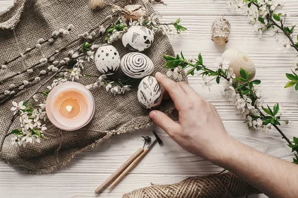 Modern Paskalya yortusu yumurta üstten görünüm rustik arka planda tutan el. tatil, Paskalya kutlamaları için hazırlık. şık boyalı yumurta... Aile gelenekleri. düz lay