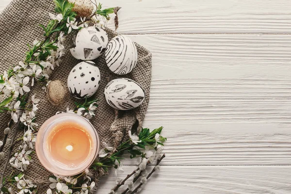 复活节快乐贺卡 现代的复活节彩蛋在质朴的白色木制背景上 有新鲜的春天的花朵和蜡烛顶部的景色 文本空间 时尚彩绘蛋平躺 — 图库照片