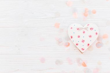pembe çerez kalp konfeti düz beyaz rustik ahşap zemin üzerine yumuşak ışık yatıyordu. Sevgililer günün kutlu olsun. mutlu anneler Kadınlar Günü tebrik kartı. metin için yer