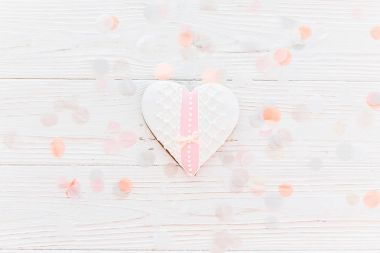 pembe çerez kalp konfeti düz beyaz rustik ahşap zemin üzerine yumuşak ışık yatıyordu. Sevgililer günün kutlu olsun. mutlu anneler Kadınlar Günü tebrik kartı. metin için yer