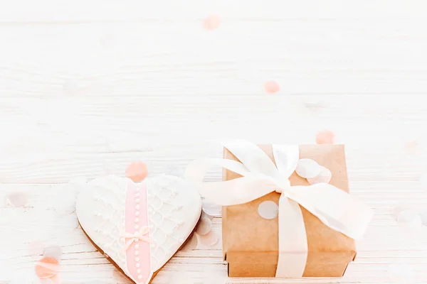 幸せなバレンタインデーのグリーティング カード クッキーの心とクラフト ギフト ボックス フラット ホワイトの素朴な木製の背景に紙吹雪を築きます テキストのためのスペース 幸せな母の日や女性の モックアップ — ストック写真