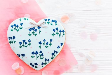 tanımlama bilgisi kalp konfeti düz beyaz rustik ahşap zemin üzerine mavi çiçekli yatıyordu. metin için yer. Mutlu Anneler Günü tebrik kartı. mutlu Sevgililer günü ya da kadın
