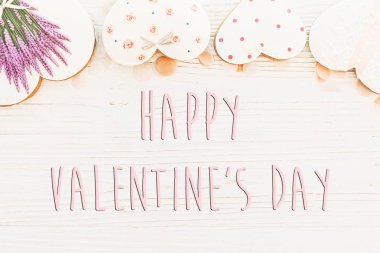 mutlu Sevgililer günü metin işaret lay düz. pembe çerez kalpleri ve konfeti beyaz rustik ahşap zemin üzerinde. metin için yer. tebrik kartı kavramı. Sevgililer parlak görüntü
