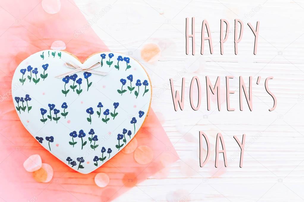 happy women's day text sign flat lay. 8 march. pink hearts  flowers and confetti on white rustic wooden background. space for text. greeting card concept. womens bright image