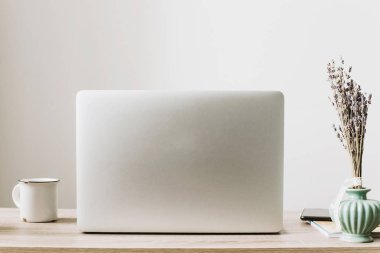 Ahşap Masaüstü telefon, defter, kahve fincanı ve şık modern oda tesisi ile laptop. Serbest kavramı. Çevrimiçi çalışıyorsanız