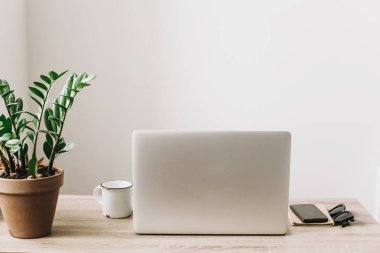 Ahşap Masaüstü telefon, defter, kahve fincanı ve şık modern oda tesisi ile laptop. Serbest kavramı. Çevrimiçi çalışıyorsanız