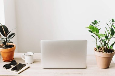 Ahşap Masaüstü telefon, defter, kahve fincanı, gözlük ve şık modern oda tesisi ile laptop. 