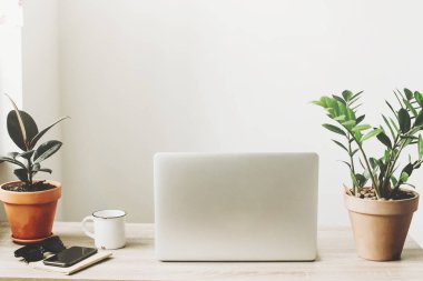 Ahşap Masaüstü telefon, defter, kahve fincanı, gözlük ve şık modern oda tesisi ile laptop. 