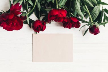 boş kartı ve çiçek kırmızı peonies buket Beyaz ahşap zemin üzerinde