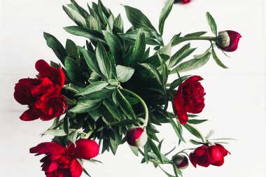 güzel kırmızı peonies buket Beyaz ahşap rustik arka planda, düz yatıyordu. metin için yer ile tebrik kartı