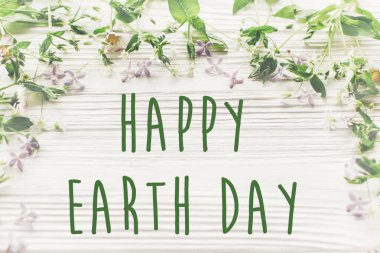 mutlu Dünya günü metni imzalamak güzel leylak ve rustik Beyaz ahşap arka plan üstten görünüm papatya çiçekler. tebrik kartı. çevre kavramı. Dünya günü. çevreyi kurtarmak. Eko