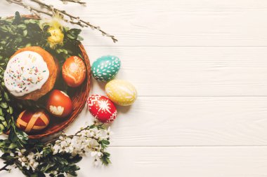 şık Paskalya yumurtaları ve Paskalya pasta ve çiçekler ahşap arka plan düz lay üzerinde ekmek. modern yumurta doğal boyalı. metin için yer. Mutlu Paskalya tebrik