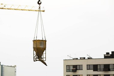 Vinç kaldırma kova çimento ve inşaat alanında yeni bina gökdelenler, taşıma. 