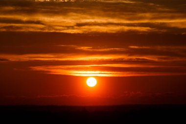 Turuncu alacakaranlıkta bulutlar şaşırtıcı kırmızı güneşe. gün batımı görüntü. güzel kırmızı bulutlu gün batımı turuncu gökyüzü, dramatik görünüm içinde. büyüleyici duvar kağıdı. güzel doğa anlar