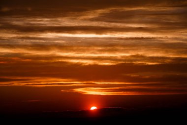 Turuncu alacakaranlıkta bulutlar şaşırtıcı kırmızı güneşe. gün batımı görüntü. güzel kırmızı bulutlu gün batımı turuncu gökyüzü, dramatik görünüm içinde. büyüleyici duvar kağıdı. güzel doğa anlar