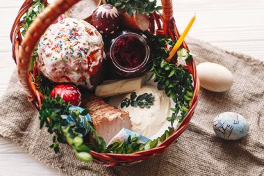 boyalı yumurta, ekmek, jambon, pancar, şık sepetle tereyağı görünümü bahar çiçek ve mum ile rustik ahşap arka plan üzerinde top. nimet Kilisesi Paskalya gıda. Mutlu Paskalya kavramı