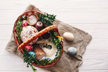 boyalı yumurta, ekmek, jambon, pancar, şık sepetle tereyağı görünümü bahar çiçek ve mum ile rustik ahşap arka plan üzerinde top. nimet Kilisesi Paskalya gıda. Mutlu Paskalya kavramı