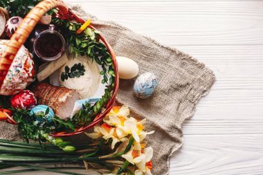 boyalı yumurta, ekmek, jambon, pancar, şık sepetle tereyağı görünümü bahar çiçek ve mum ile rustik ahşap arka plan üzerinde top. nimet Kilisesi Paskalya gıda. Mutlu Paskalya kavramı