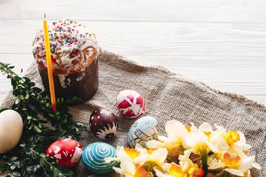 Mutlu Paskalya kavramı. şık boyalı yumurta ve Paskalya kek üzerine beyaz rustik ahşap arka plan bahar çiçek ve mum ile. mevsim Selam. metin için yer. Modern Paskalya görüntü
