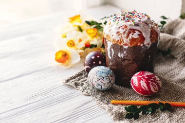 Mutlu Paskalya kavramı. şık boyalı yumurta ve Paskalya kek üzerine beyaz rustik ahşap arka plan bahar çiçek ve mum ile. mevsim Selam. metin için yer. Modern Paskalya görüntü