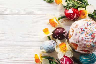 şık boyalı yumurta ve Paskalya kek bahar çiçekleri, üstten görünüm rustik ahşap zemin üzerine. metin için yer. Mutlu Paskalya kavramı, modern düz yatıyordu. mevsim Selam
