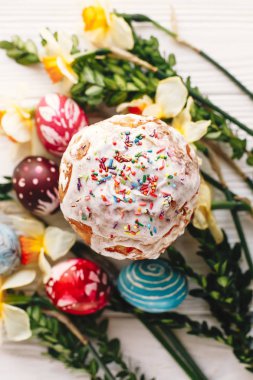 Mutlu Paskalya kavramı. şık boyalı yumurta ve Paskalya kek bahar çiçekleri, üstten görünüm rustik ahşap zemin üzerine. mevsim tebrik kartı. metin için yer. Modern düz lay