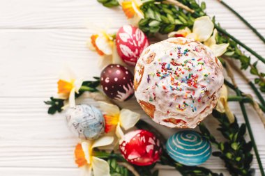 şık boyalı yumurta ve Paskalya kek bahar çiçekleri, üstten görünüm rustik ahşap zemin üzerine. metin için yer. Mutlu Paskalya kavramı, modern düz yatıyordu. mevsim Selam