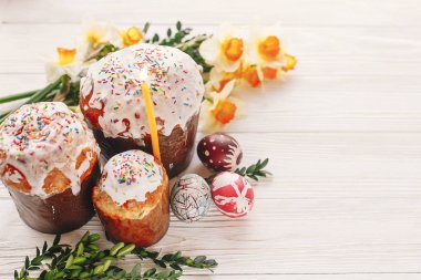 Mutlu Paskalya kavramı. şık boyalı yumurta ve Paskalya kek üzerine beyaz rustik ahşap arka plan bahar çiçek ve mum ile. mevsim Selam. metin için yer. Modern Paskalya görüntü