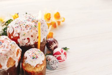 Mutlu Paskalya kavramı. şık boyalı yumurta ve Paskalya kek üzerine beyaz rustik ahşap arka plan bahar çiçek ve mum ile. mevsim Selam. metin için yer. Modern Paskalya görüntü