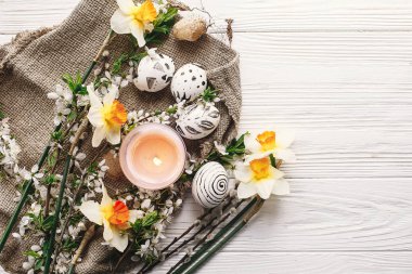 şık Paskalya düz yatıyordu. Paskalya yumurtaları rustik ahşap arka plan bahar çiçek ve mum ile siyah ve beyaz renklere boyanmış. Mutlu Paskalya tebrik kartı. Modern Paskalya yumurtaları görünümü top.