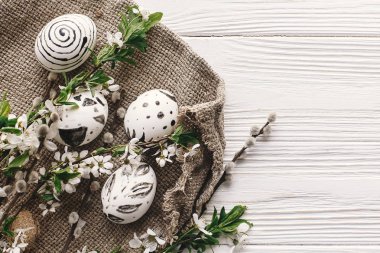 şık Paskalya yumurtaları rustik ahşap arka plan bahar çiçekleri ile siyah ve beyaz renklere boyanmış. Mutlu Paskalya tebrik kartı. Modern Paskalya yumurtaları görünümü top. minimalist tatil resim