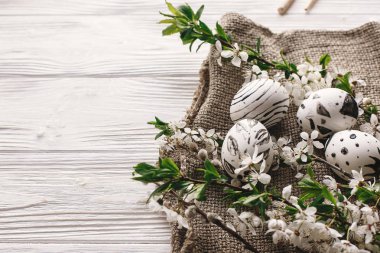 şık Paskalya yumurtaları rustik ahşap arka plan bahar çiçekleri ile siyah ve beyaz renklere boyanmış. Mutlu Paskalya tebrik kartı. Modern Paskalya yumurtaları görünümü top. minimalist tatil resim