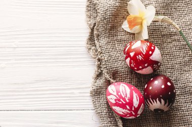 Mutlu Paskalya kavramı. rustik ahşap arka plan bahar çiçekleri ve Söğüt dalları ile şık boyalı yumurta. mevsim tebrik kartı. metin için yer. Modern renkli Paskalya yumurtaları