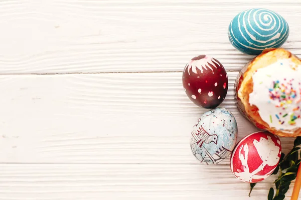 şık boyalı yumurta ve Paskalya kek bahar çiçekleri, üstten görünüm rustik ahşap zemin üzerine. metin için yer. Mutlu Paskalya kavramı, modern düz yatıyordu. mevsim Selam