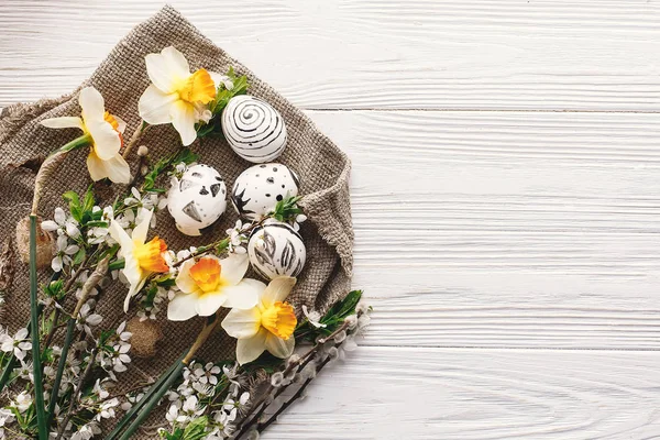 şık Paskalya düz boyalı Paskalya yortusu yumurta siyah ve beyaz rustik ahşap arka plan bahar çiçekleri nergis ile adlı yatırın. Mutlu Paskalya tebrik kartı. görünümü, metin için yer modern Paskalya yumurta top