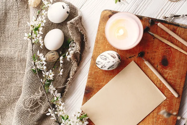 rustik ahşap arka plan bahar çiçek ve mum ile şık boyalı Paskalya yortusu yumurta siyah ve beyaz renklere. Mutlu Paskalya tebrik kartı. Modern Paskalya yumurtaları görünümü top. tatil gelenekleri