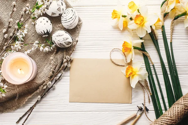 şık Paskalya düz yatıyordu. Paskalya yumurtaları rustik ahşap arka plan bahar çiçek ve mum ile siyah ve beyaz renklere boyanmış. Mutlu Paskalya tebrik kartı. Modern Paskalya yumurtaları görünümü top.