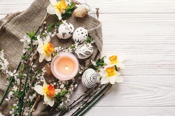 şık Paskalya düz yatıyordu. Paskalya yumurtaları rustik ahşap arka plan bahar çiçek ve mum ile siyah ve beyaz renklere boyanmış. Mutlu Paskalya tebrik kartı. Modern Paskalya yumurtaları görünümü top.