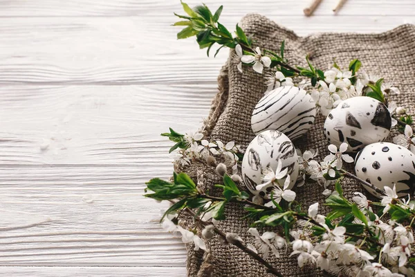 şık Paskalya yumurtaları rustik ahşap arka plan bahar çiçekleri ile siyah ve beyaz renklere boyanmış. Mutlu Paskalya tebrik kartı. Modern Paskalya yumurtaları görünümü top. minimalist tatil resim