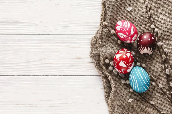 şık Paskalya düz yatıyordu. Bahar rustik ahşap zemin üzerine boyalı yumurta dalları söğüt. Mutlu Paskalya tebrik kartı. metin için yer. Modern renkli Paskalya yumurtaları