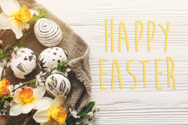 Mutlu Paskalya metin. sezon selamlar card.stylish Paskalya düz yatıyordu. rustik ahşap arka plan bahar çiçekleri nergis ile yumurta boyalı. Modern Üstten Görünüm,