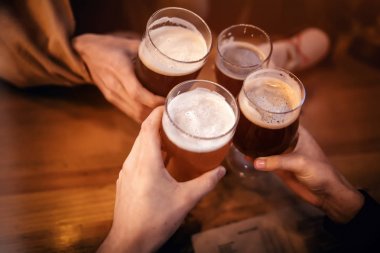 sorun ve lezzetli zanaat bira ile kızartma arkadaşlar çubuk. Grup tezahürat ve barda bir bira zevk insan. bardak bira holding eller. Eğlence ve dostluk kavramı 