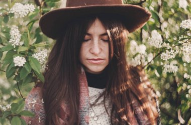 Yeşil poz şapkalı güzel hippi kız Akşam güneşiyle çiçek bırakır. şık kadın Gezgin bahar bahçe sakin portre. metin için yer. Atmosferik an