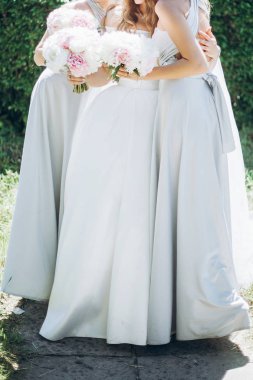 güzel nedime ve şık Şakayık buketleri sabah bahar bahçe içinde tutarak gelin. muhteşem bir kadın inanılmaz ipek güneşli parkta poz Giydir. düğün günü